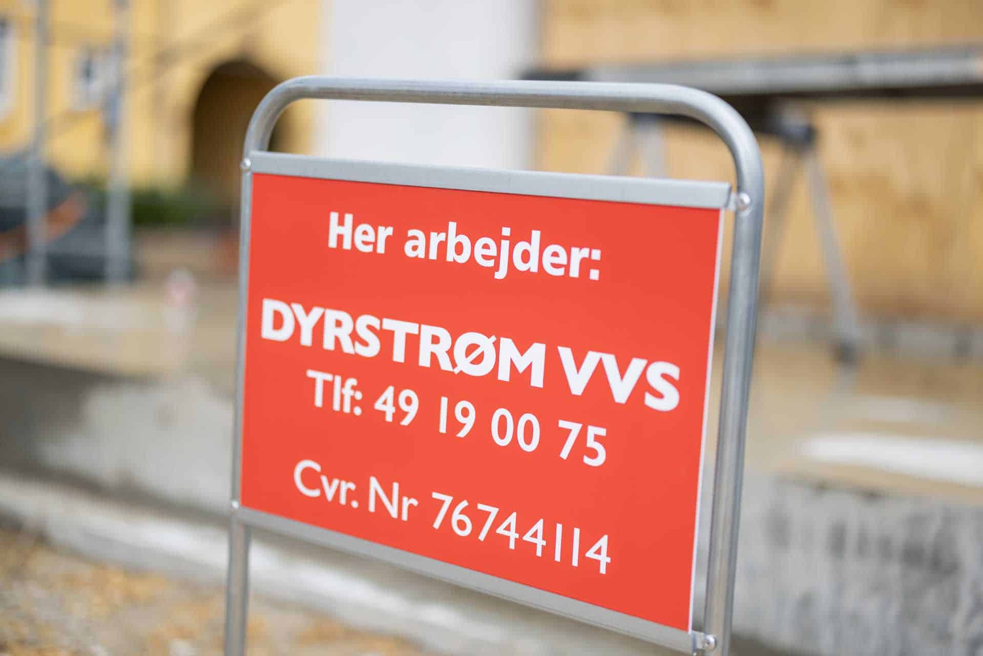 Arbejdsskilt på byggeplads - "Her arbejder: DYRSTRØM VVS Tlf: 49 19 00 75 Cvr. Nr. 76744114"